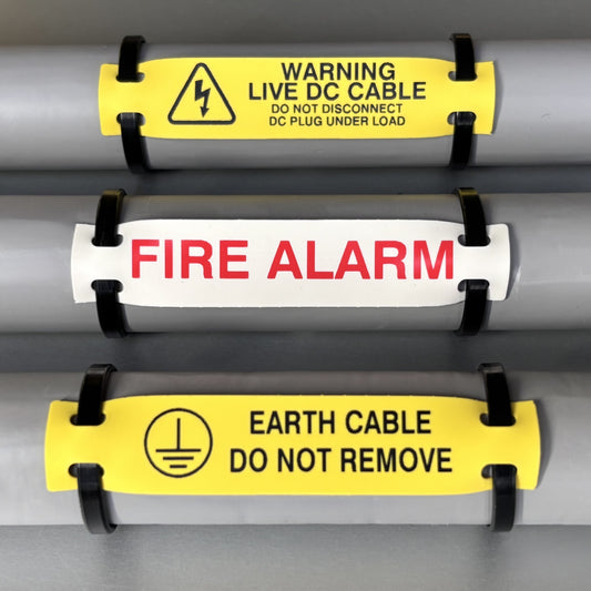 Three warning labels on a cable with text and symbols.