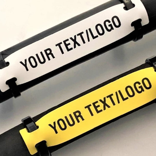 Two customizable name tags, one black and white, the other yellow with black text, on a gray background.
